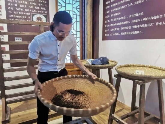 2023“一帶一路”媒體合作論壇聯(lián)合采訪團(tuán)團(tuán)員在非遺文化展示館體驗(yàn)中藥炮制技藝。（本報(bào)記者 黃超攝）