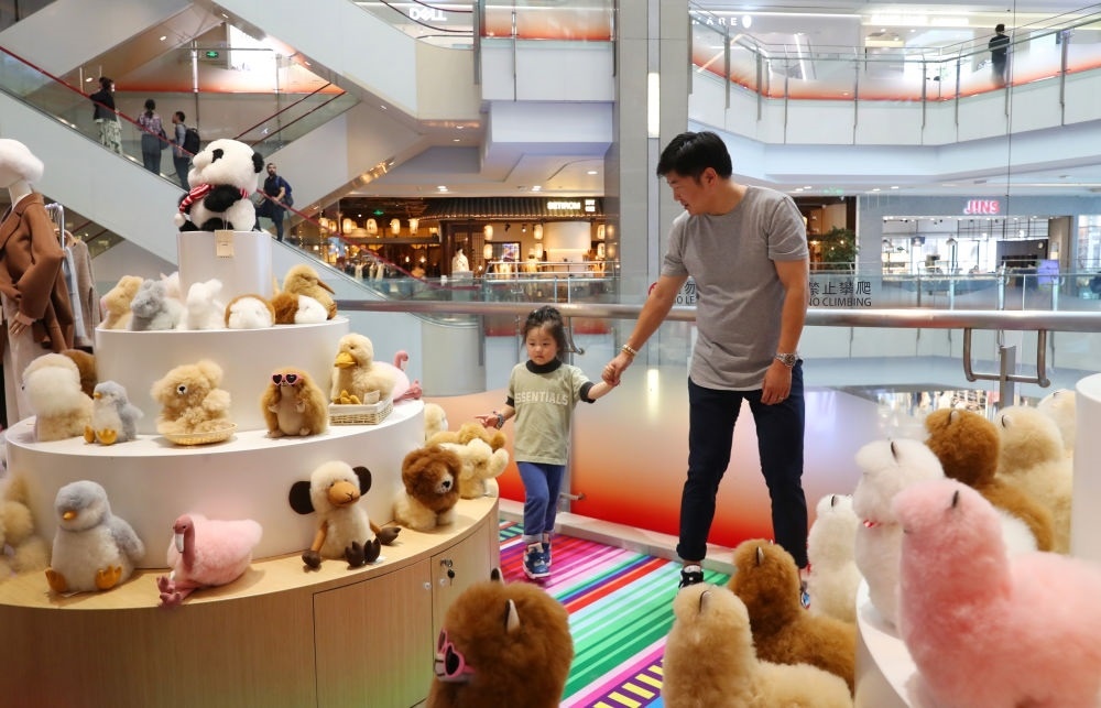 2023年11月2日，顧客在溫暖駝品牌專柜內(nèi)選購。連續(xù)六年參加進(jìn)博會的秘魯羊駝制品品牌溫暖駝在上海市中心商場開設(shè)了專柜。新華社記者 方喆 攝