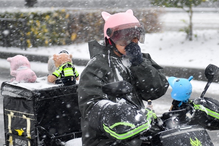11月6日，在長(zhǎng)春市街頭，一名外賣員在雪中騎行。新華社記者 許暢 攝