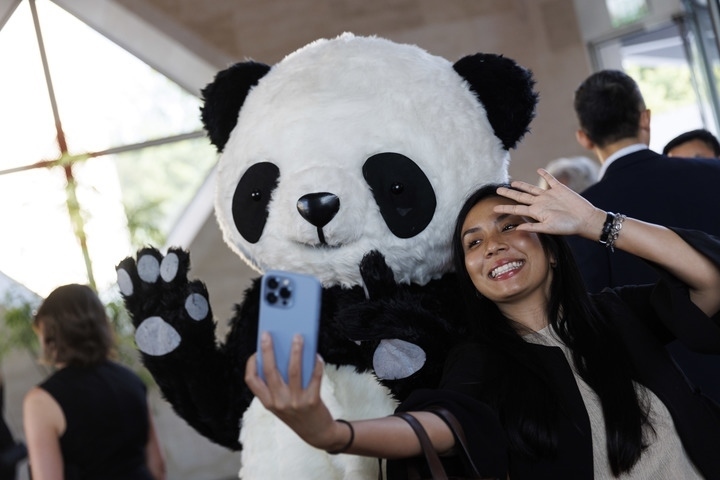 2022年8月24日，在美國華盛頓中國駐美國大使館，來賓與大熊貓玩偶合影。