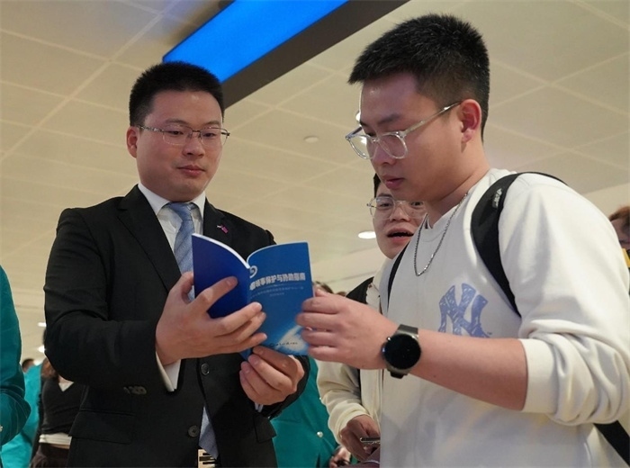 工作人員（左一）在發(fā)放《中國領(lǐng)事保護(hù)與協(xié)助指南》。 中國駐迪拜總領(lǐng)事館供圖