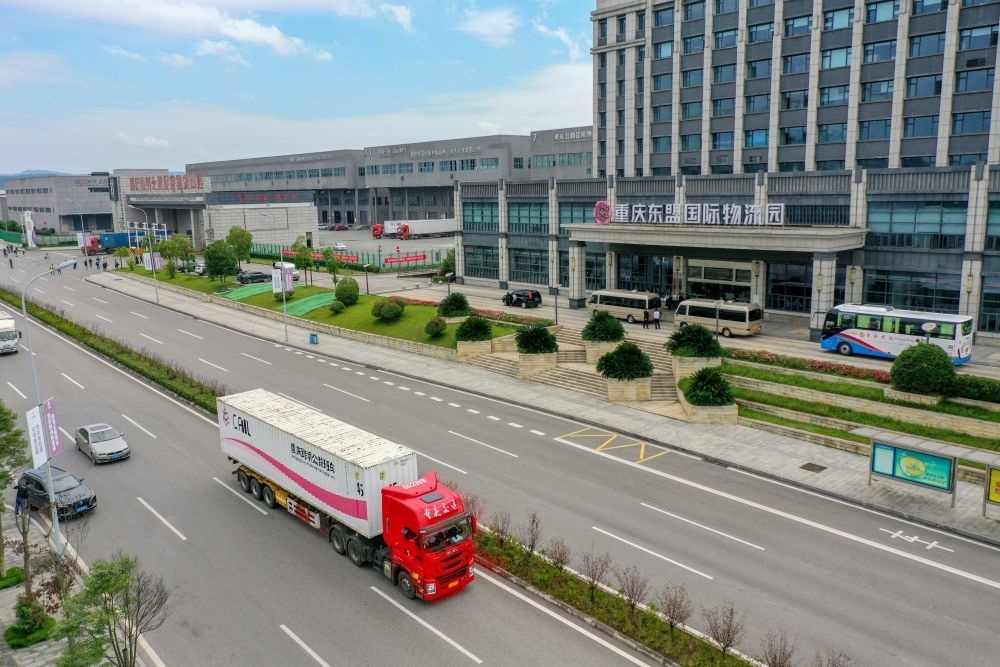 2023年10月11日，滿載筆記本電腦配件、發(fā)電機(jī)組件等產(chǎn)品的西部陸海新通道跨境公路班車從重慶南彭公路保稅物流中心駛出，將途經(jīng)廣西憑祥，直達(dá)越南（無(wú)人機(jī)照片）。新華社記者 黃偉 攝