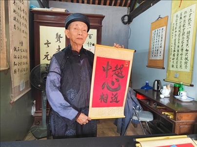 越南首都河內(nèi)文廟內(nèi)，阮明珠展示“中越心相近”書法作品。