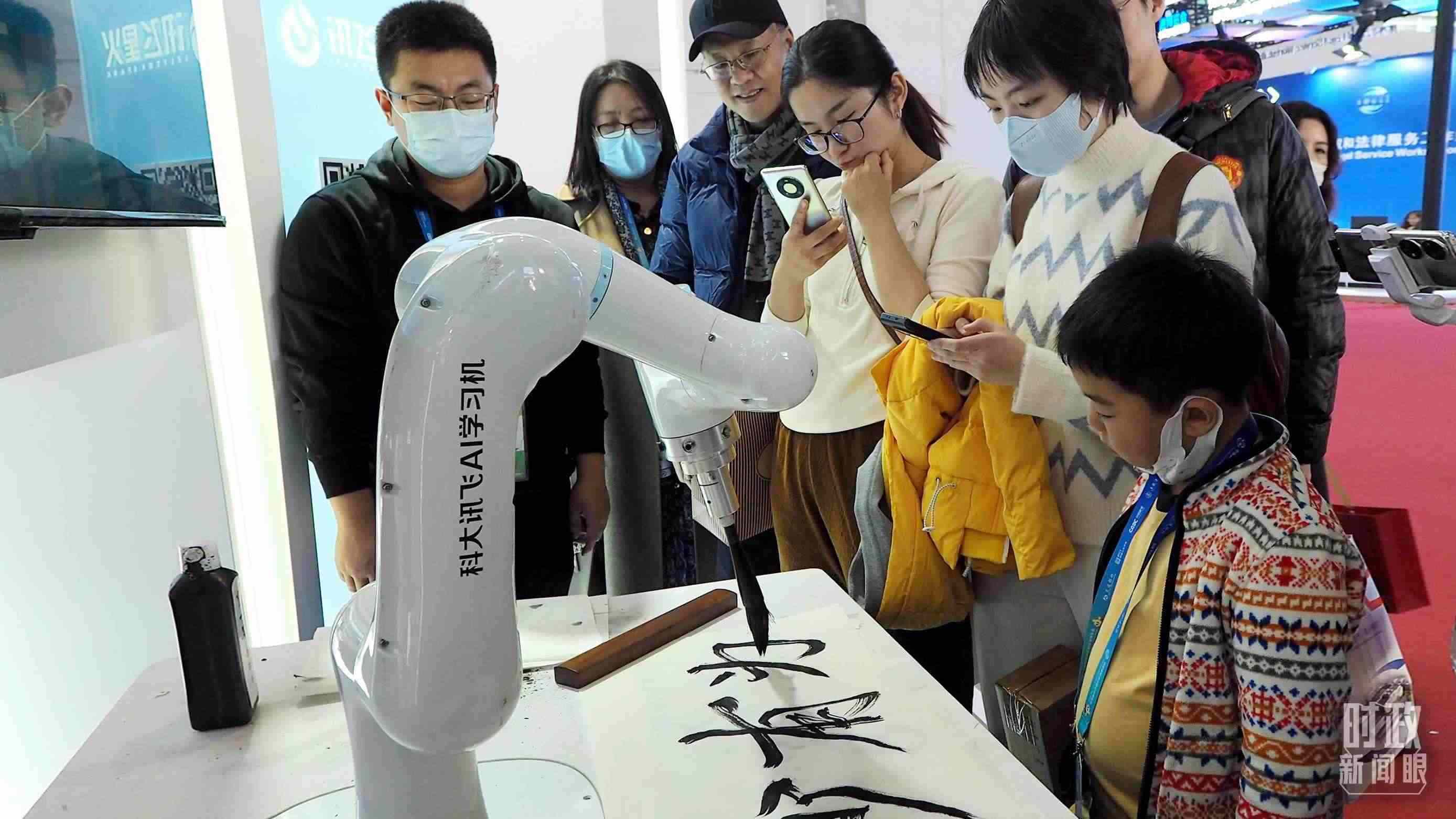 △觀眾在首屆鏈博會(huì)上體驗(yàn)AI書法機(jī)器人。