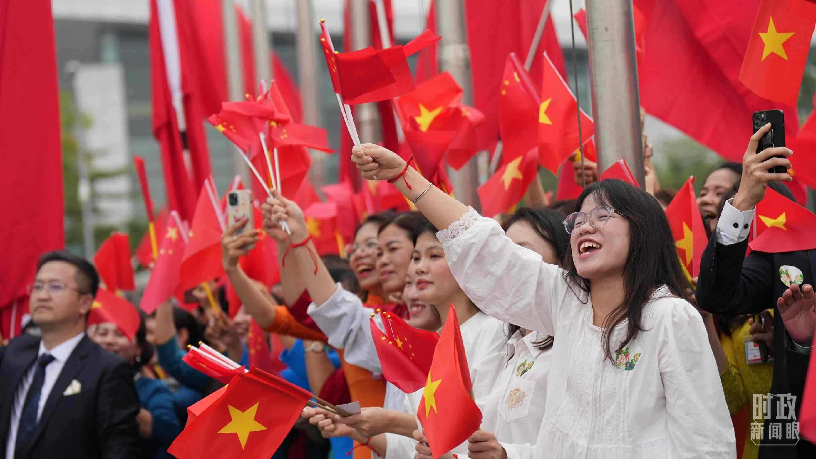 △人們揮舞兩國旗幟歡迎習(xí)近平訪越。（總臺國廣記者李晉拍攝）