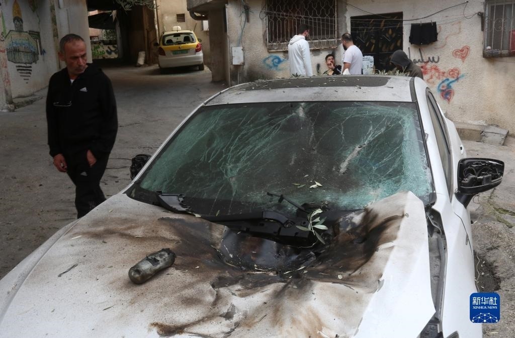 12月17日，在約旦河西岸城市圖勒凱爾姆附近的一處難民營(yíng)，人們查看在沖突中損毀的車輛。新華社發(fā)（尼達(dá)爾·艾仕塔耶?dāng)z）
