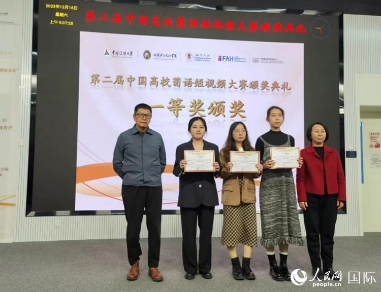 澳門大學(xué)中葡雙語教學(xué)暨培訓(xùn)中心主任姚京明（左一）和中國傳媒大學(xué)外國語言文化學(xué)院院長文春英（右一）為一等獎獲得者頒獎。人民網(wǎng)記者 魯揚攝