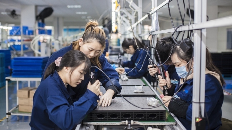 在新亞勝光電的產(chǎn)品線上，工人正進(jìn)行產(chǎn)品組建和安裝布線。受訪者供圖
