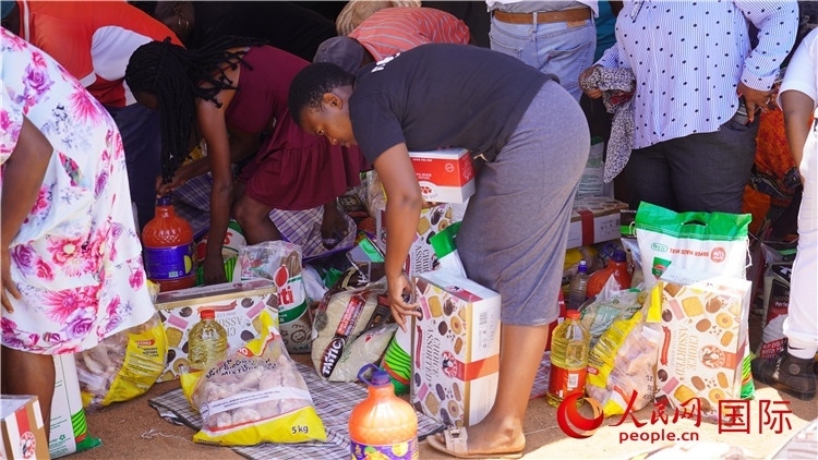 當?shù)厣鐓^(qū)家庭領取物資。人民網(wǎng) 張茜攝