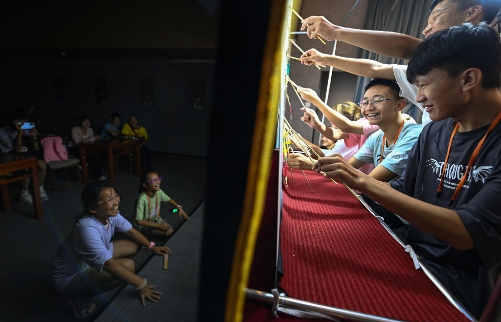 2023年8月8日，進行暑期研學(xué)的學(xué)生在位于陜西省西安市的中國秦腔藝術(shù)博物館體驗皮影戲演出。新華社記者 鄒競一 攝