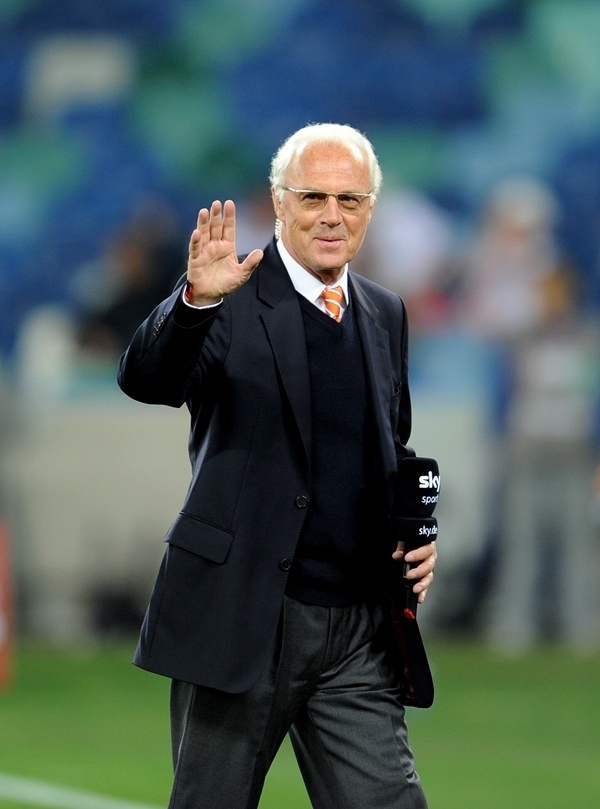 這是2010年7月7日，在南非德班舉行的2010年足球世界杯德國(guó)隊(duì)對(duì)陣西班牙隊(duì)的半決賽前，貝肯鮑爾接受電視臺(tái)采訪(fǎng)時(shí)和友人打招呼。新華社記者 王毓國(guó) 攝