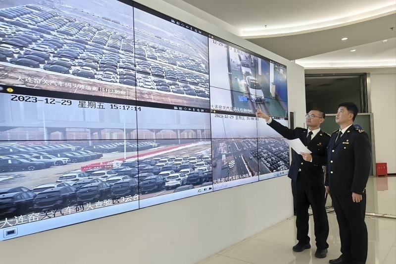 海關(guān)關(guān)員視頻巡查出口汽車場地。李進(jìn)攝