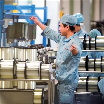 在位于武漢的長飛光纖光纜股份有限公司光纖生產(chǎn)車間內(nèi)，工作人員對光纖進行檢測（資料圖片）。肖藝九攝/本刊