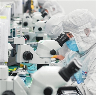 在位于武漢中國光谷的光電器件研發(fā)制造商——武漢光迅科技股份有限公司生產(chǎn)車間內(nèi)，技術(shù)人員在光模塊生產(chǎn)線作業(yè)（2023年4月11日攝）。程敏攝/本刊