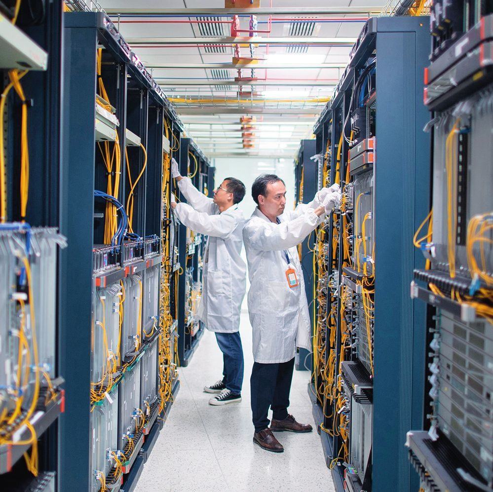 在位于武漢中國光谷的光電器件研發(fā)制造商——武漢光迅科技股份有限公司生產(chǎn)車間內(nèi)，技術(shù)人員在光模塊生產(chǎn)線作業(yè)（2023年4月11日攝）。程敏攝/本刊