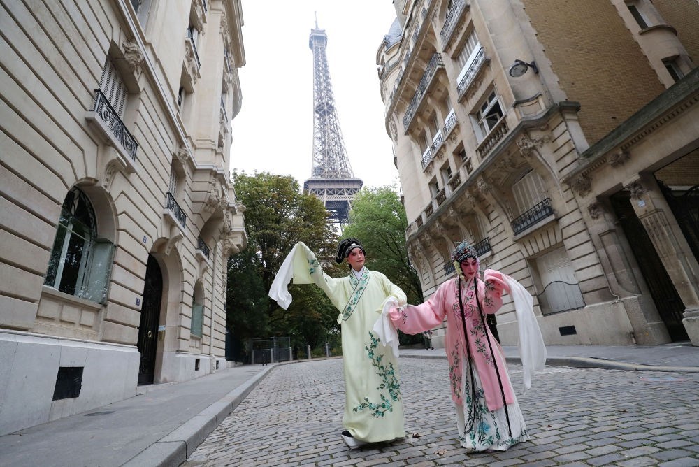 2023年9月13日，江蘇省演藝集團(tuán)昆劇院院長(zhǎng)施夏明（左）和江蘇省演藝集團(tuán)昆劇院國(guó)家一級(jí)演員孔愛(ài)萍在法國(guó)巴黎埃菲爾鐵塔附近參加昆曲快閃。新華社記者 高靜 攝