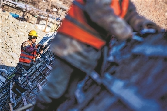 1月3日，房山區(qū)，工人正在雙泉河修筑堤壩。