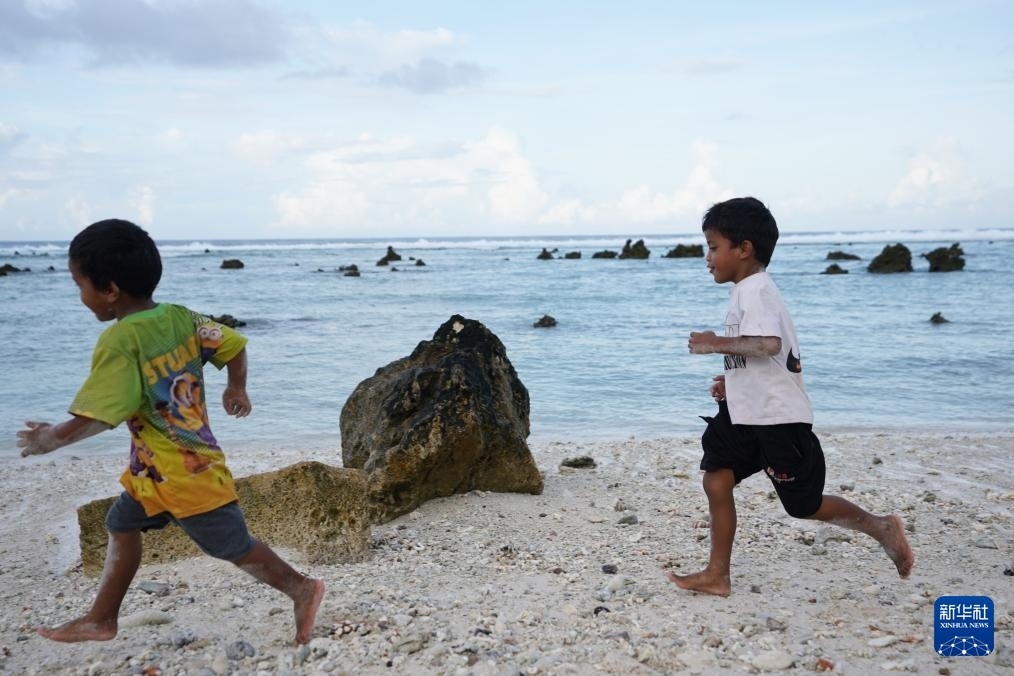 1月20日，兒童在瑙魯海邊嬉戲。新華社記者 王申 攝