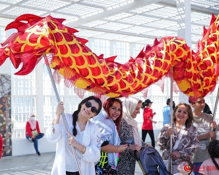 游客體驗(yàn)舞龍。 人民網(wǎng) 塔里克·易卜拉欣攝