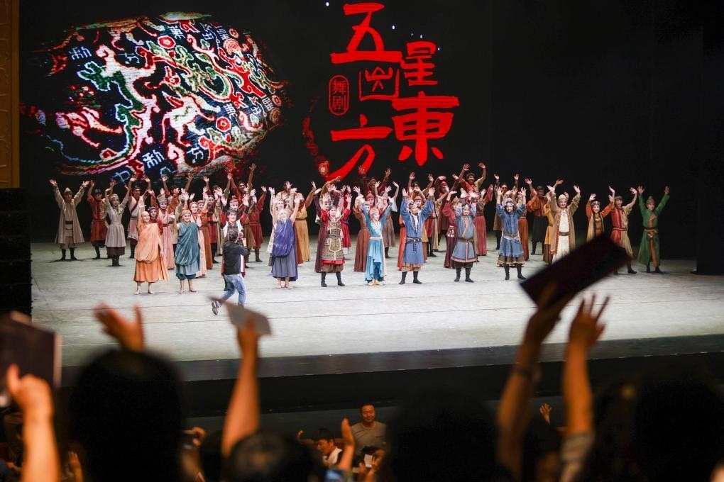 2023年7月31日，新疆和田地區(qū)新玉歌舞團(tuán)在烏魯木齊京劇院演出舞劇《五星出東方》后和觀眾互相揮手致意。這場演出是第六屆中國新疆國際民族舞蹈節(jié)的參演劇目之一，曾榮獲國家“文華獎”等。新華社記者 郝昭 攝