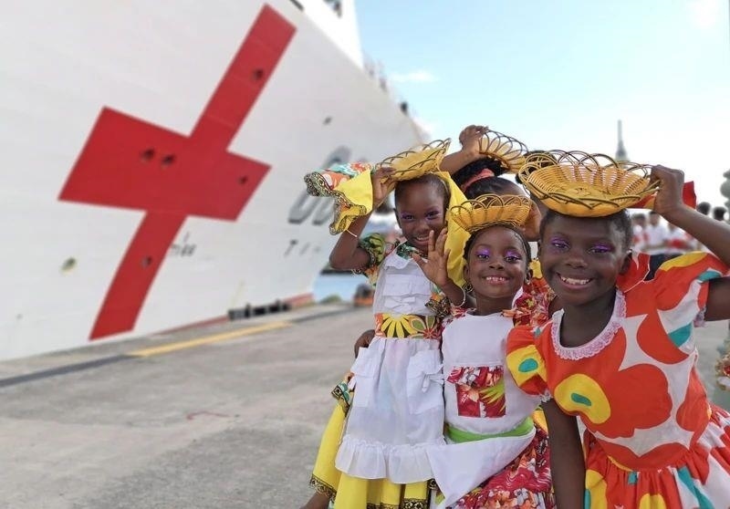 2018年10月，在安提瓜和巴布達首都圣約翰，當?shù)匦∨笥焉泶﹤鹘y(tǒng)服裝歡迎中國海軍“和平方舟”醫(yī)院船首次到訪。