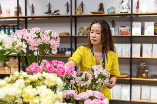 2023年7月1日，在位于湖南省長沙市的湖南高橋大市場，中非經(jīng)貿(mào)博覽會常設(shè)展館展區(qū)肯尼亞館工作人員在整理產(chǎn)自非洲的鮮花。新華社記者 陳思汗 攝