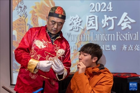 1月28日，在上海豫園舉行的民俗活動上，美國馬斯卡廷中學(xué)學(xué)生在非遺傳承人的指導(dǎo)下吹糖偶。 新華社記者 王翔 攝