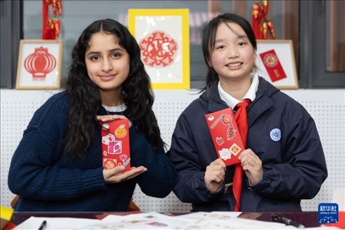 1月28日，美國馬斯卡廷中學(xué)學(xué)生（左）和復(fù)旦大學(xué)第二附屬學(xué)校學(xué)生展示互相送出的寫有寄語祝福的紅包。 新華社記者 王翔 攝