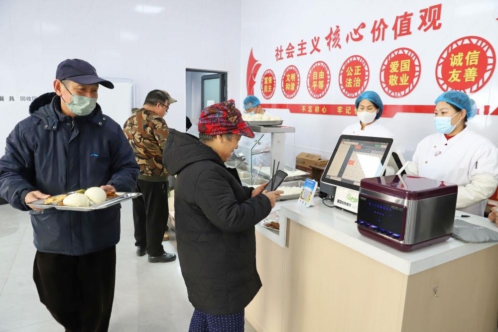 △2024年2月1日，市民在河北涿州市雙塔街道永濟(jì)秀園小區(qū)便民食堂內(nèi)購買午餐。