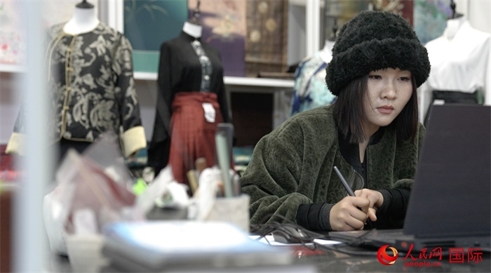 1月23日，在山東省菏澤市曹縣有愛云倉直播基地，張子晨正在設(shè)計漢服。 人民網(wǎng)記者 袁蒙攝