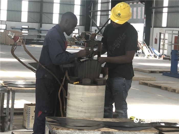 經(jīng)貿(mào)合作區(qū)廠房內(nèi)，當?shù)毓と苏诰o張作業(yè)。人民網(wǎng)記者 黃培昭攝