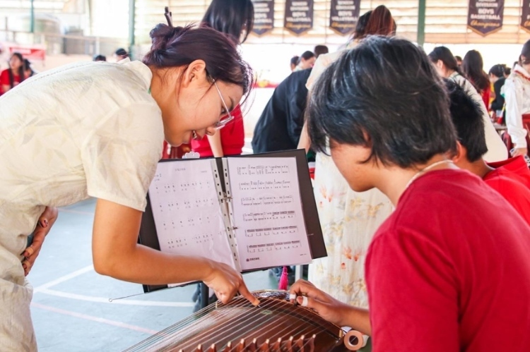 志愿者教師指導(dǎo)學(xué)生彈奏古箏?；顒?dòng)主辦方供圖