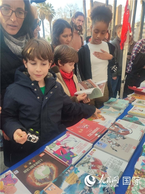 印刷精美的中國傳統(tǒng)文化叢書吸引了小游客的注意。人民網(wǎng)記者鄭彬攝