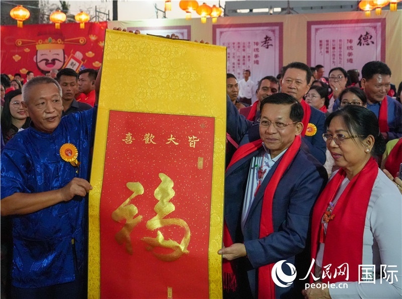 敏昂萊主席夫婦在“錦繡唐人街”新春慶典活動現(xiàn)場體驗(yàn)中國傳統(tǒng)書法藝術(shù)-人民網(wǎng)記者謝佳君攝