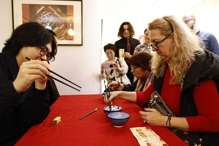 羅馬尼亞觀眾體驗(yàn)用筷子夾花生。中國文化中心供圖