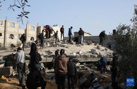  3月3日，在加沙地帶南部城市拉法，人們查看被以軍空襲破壞的建筑。新華社發(fā)（哈立德·奧馬爾攝）