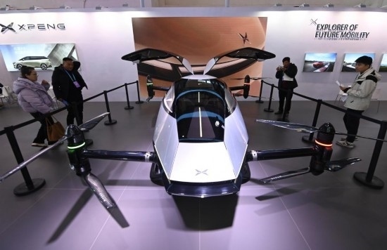 2023年12月1日，在鏈博會(huì)智能汽車鏈展區(qū)小鵬汽車展臺(tái)，參觀者觀看一臺(tái)智能飛行器。新華社記者蔡湘鑫攝