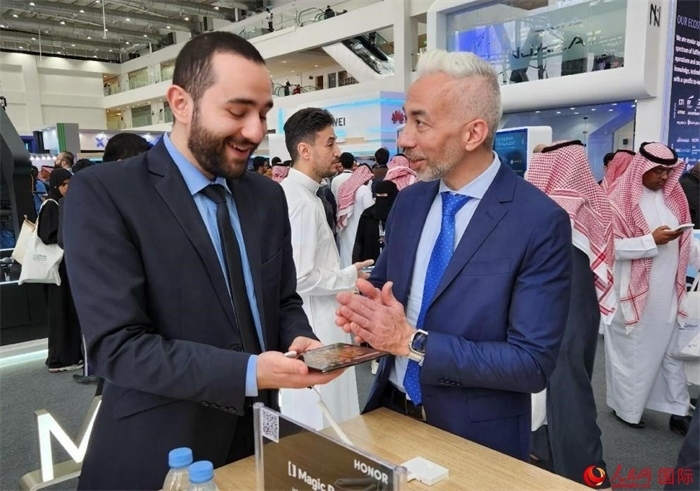 兩名觀眾在榮耀手機(jī)展臺(tái)前交流。人民網(wǎng)記者 管克江攝