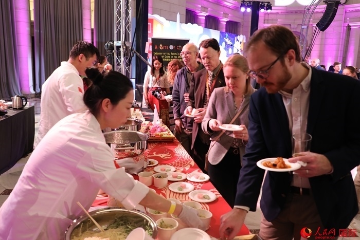 當(dāng)?shù)貢r間3月7日晚，華盛頓聯(lián)合車站廣場舉行駐美使團(tuán)“使館主廚挑戰(zhàn)賽”。圖為當(dāng)?shù)孛癖娫谥袊古_前體驗(yàn)中國美食。人民網(wǎng)記者 李志偉攝