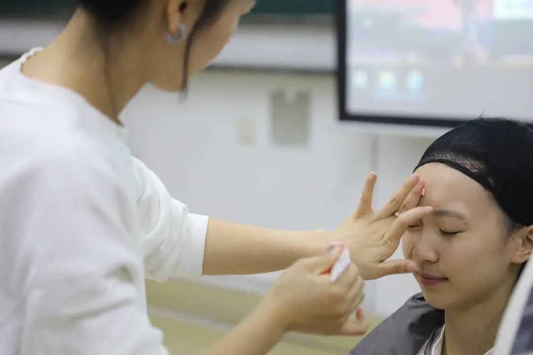 課堂上，一名學(xué)生在體驗(yàn)上戲妝。學(xué)校供圖