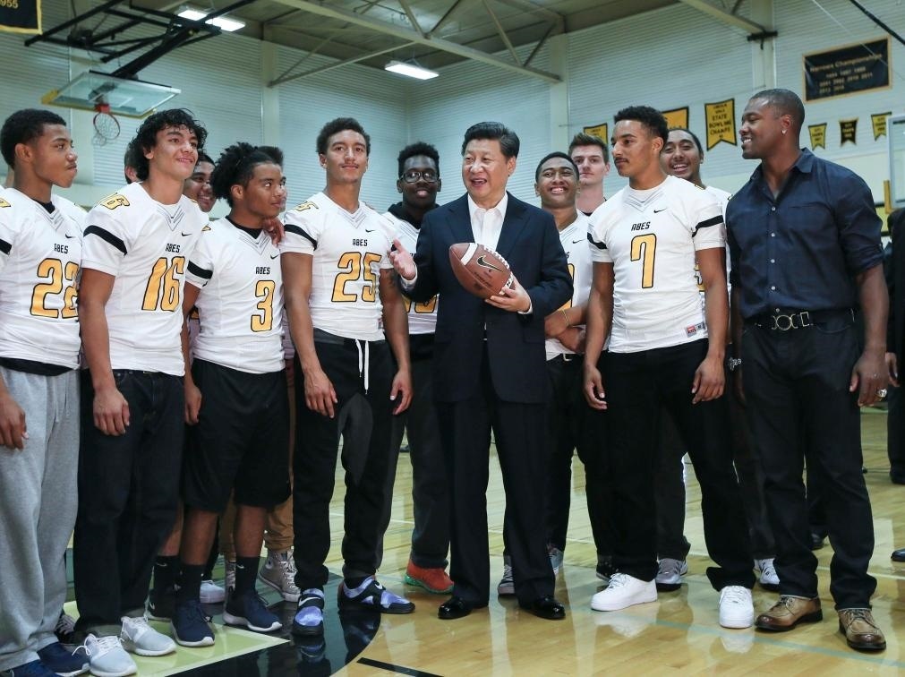 2015年9月23日，國家主席習(xí)近平參觀美國塔科馬市林肯中學(xué)。這是習(xí)近平在學(xué)校體育館，同上橄欖球訓(xùn)練課的學(xué)生們親切交談。新華社記者 蘭紅光 攝