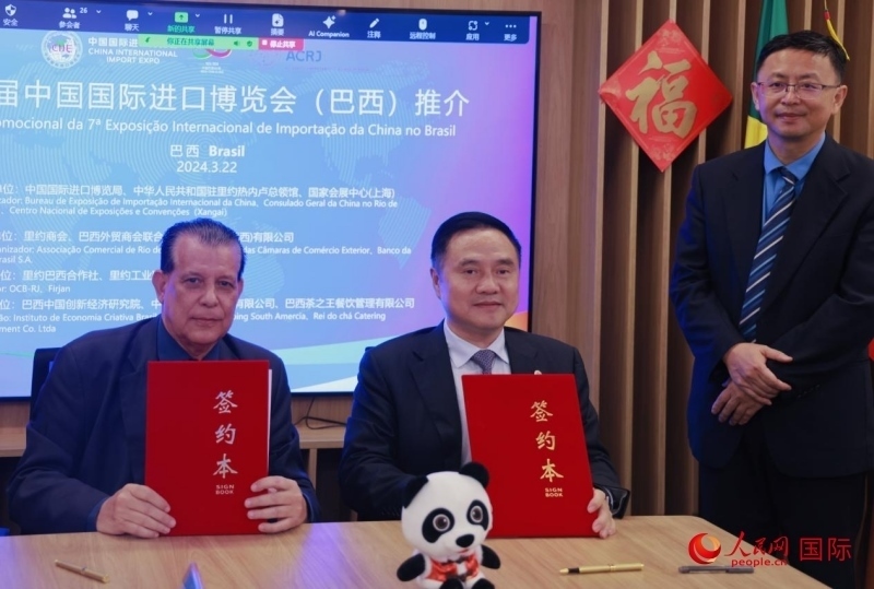 巴西外貿商會聯(lián)合會會長阿代爾·羅伯托（左）與中國國際進口博覽局副局長吳政平（中）現場簽訂協(xié)議。人民網記者 宋亦然攝