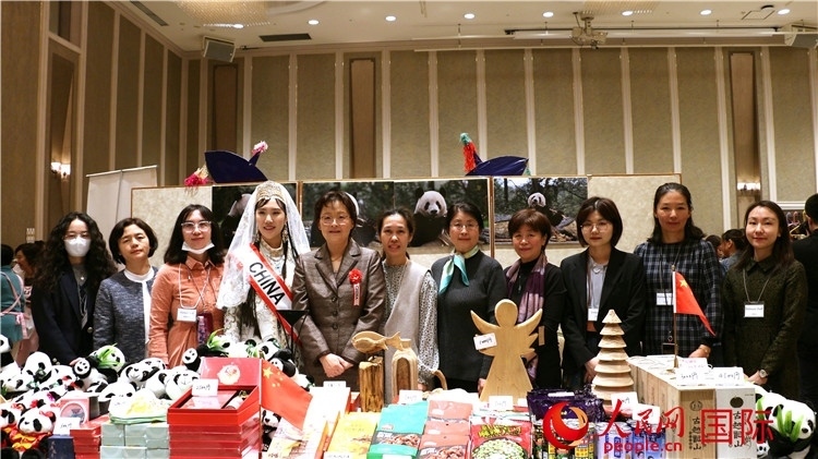 中國駐日本大使吳江浩夫人丁玥（左五）與使館人員在展位前合影留念。人民網(wǎng) 許可攝