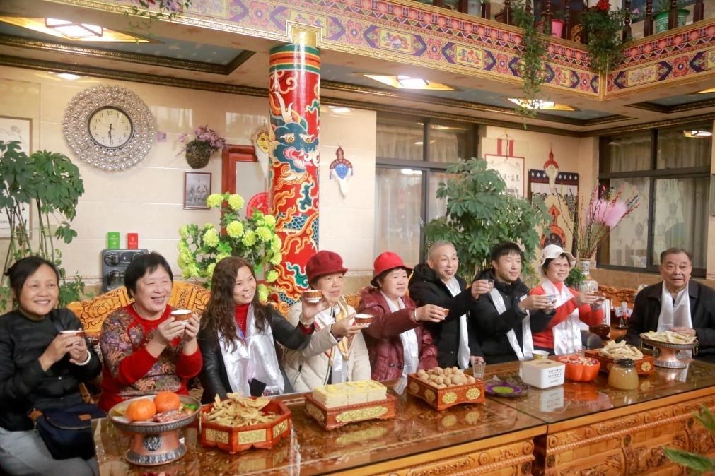 游客們?nèi)胱∶袼藓螅e杯共飲酥油茶。新華社記者 邱星翔 攝