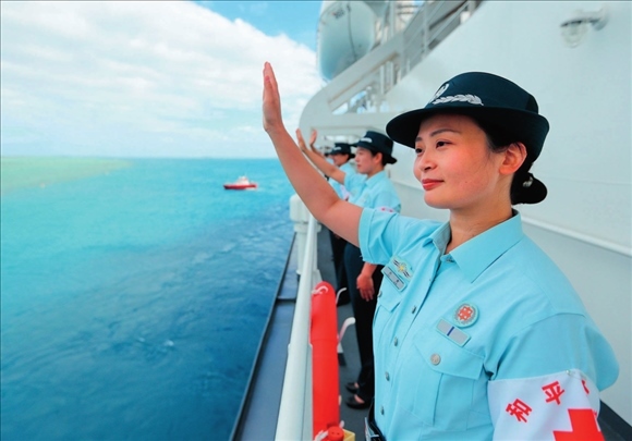 中國海軍“和平方舟”號醫(yī)院船結(jié)束訪問湯加時，任務(wù)官兵中的文職人員向歡送人群揮手告別（2023年8月4日攝）。徐巍攝/本刊