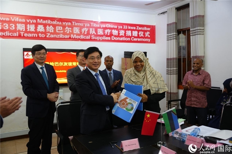 江蘇省蘇北人民醫(yī)院黨委書記束余聲與桑衛(wèi)生部首席秘書哈比巴交換捐贈(zèng)書。中國援桑醫(yī)療隊(duì)供圖