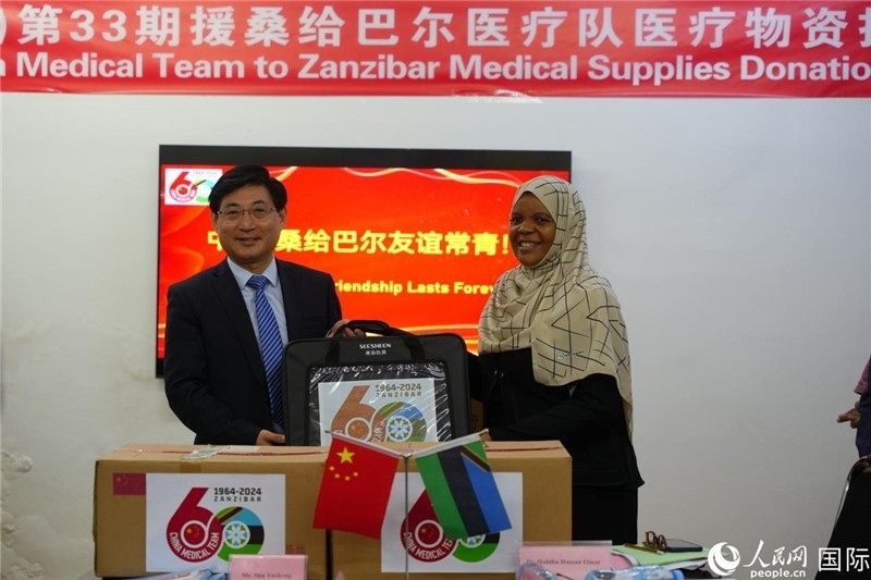 江蘇省蘇北人民醫(yī)院黨委書記束余聲捐贈(zèng)物資與桑衛(wèi)生部首席秘書哈比巴。中國援桑醫(yī)療隊(duì)供圖
