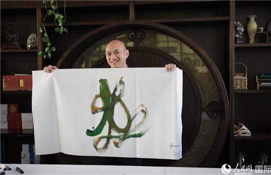 老撾駐華大使館三秘明君參加《五百筆·瀾湄合作》集體藝術(shù)創(chuàng)作。人民網(wǎng)王婧攝。