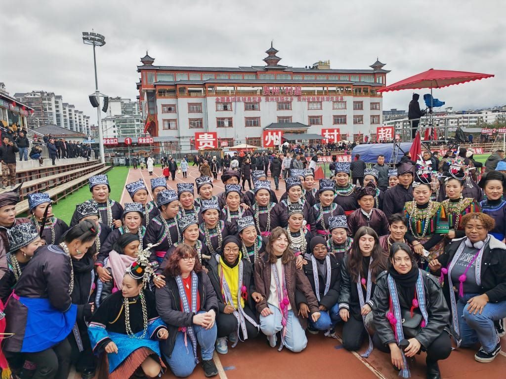 法國(guó)青年在“村超”賽場(chǎng)邊與參加表演的村民合影。新華社記者 羅羽 攝