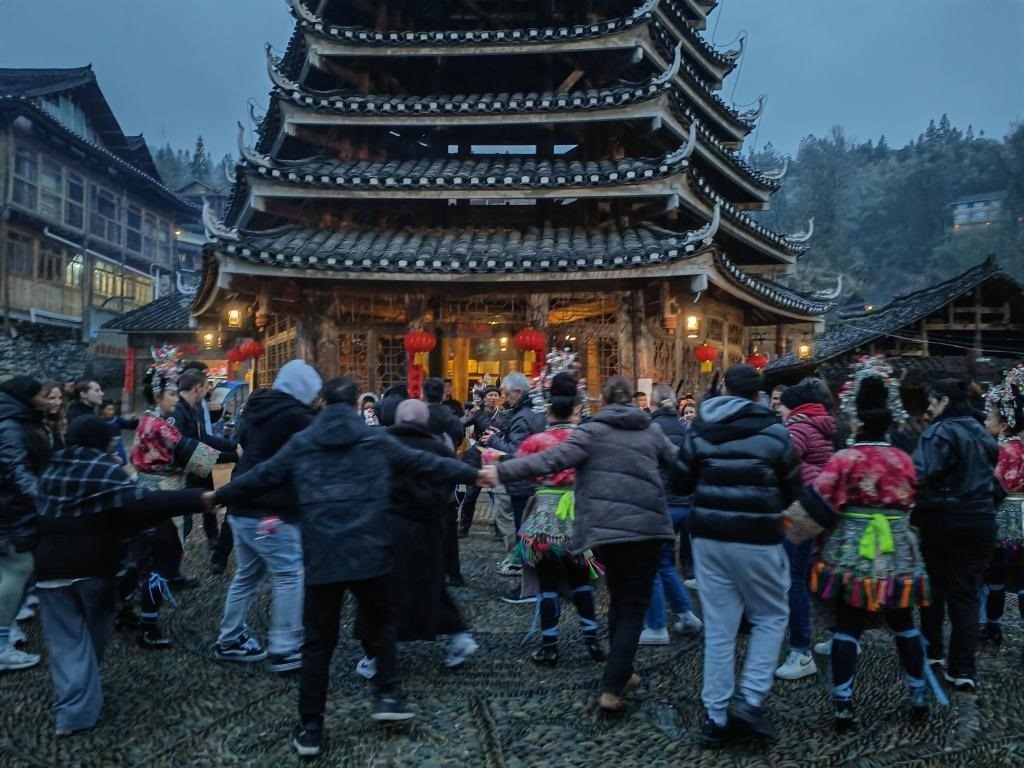 法國(guó)青年與當(dāng)?shù)卮迕駹渴痔?。新華社記者 羅羽 攝